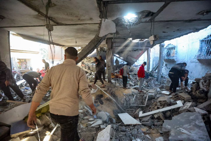 הפלסטינים מתגודדים ליד בניין הרוס - ונמלטים מח'אן יונס