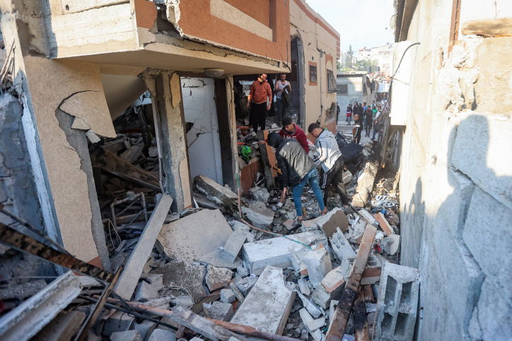 הפלסטינים מתגודדים ליד בניין הרוס - ונמלטים מח'אן יונס