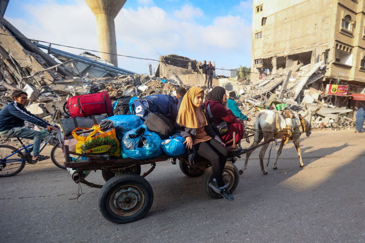 הפלסטינים מתגודדים ליד בניין הרוס - ונמלטים מח'אן יונס