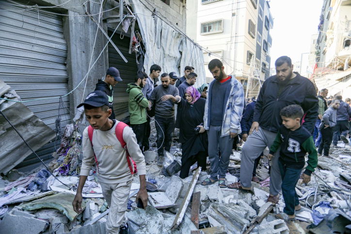 הפלסטינים מתגודדים ליד בניין הרוס - ונמלטים מח'אן יונס