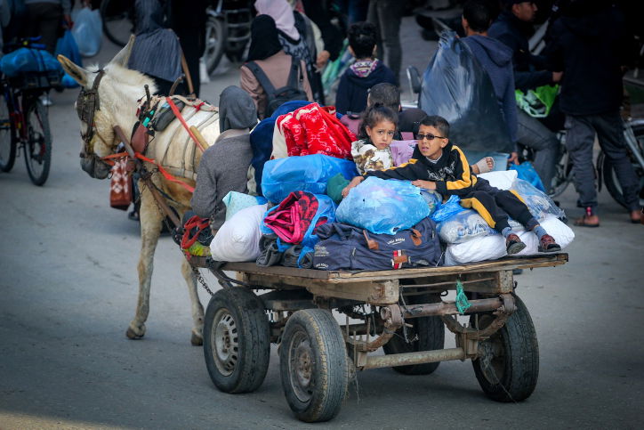 הפלסטינים מתגודדים ליד בניין הרוס - ונמלטים מח'אן יונס