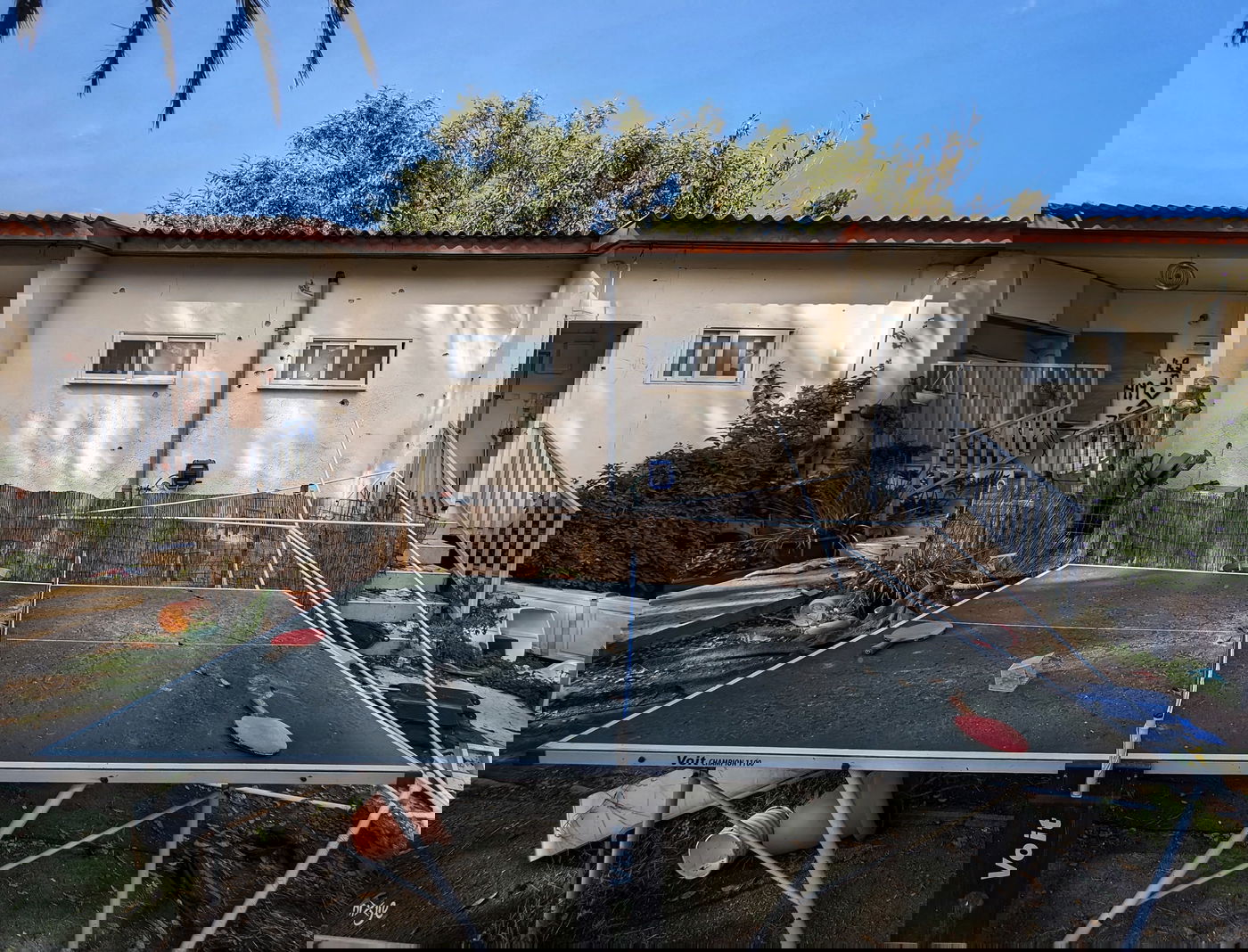 שולחן משחקים שברקע בית מנוקב מכדורי המרצחים ימ"ש