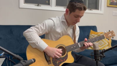 אמן הגיטרה הצעיר מבצע את הניגון המודז'יצאי