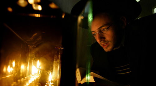 בחור מדליק חנוכיה