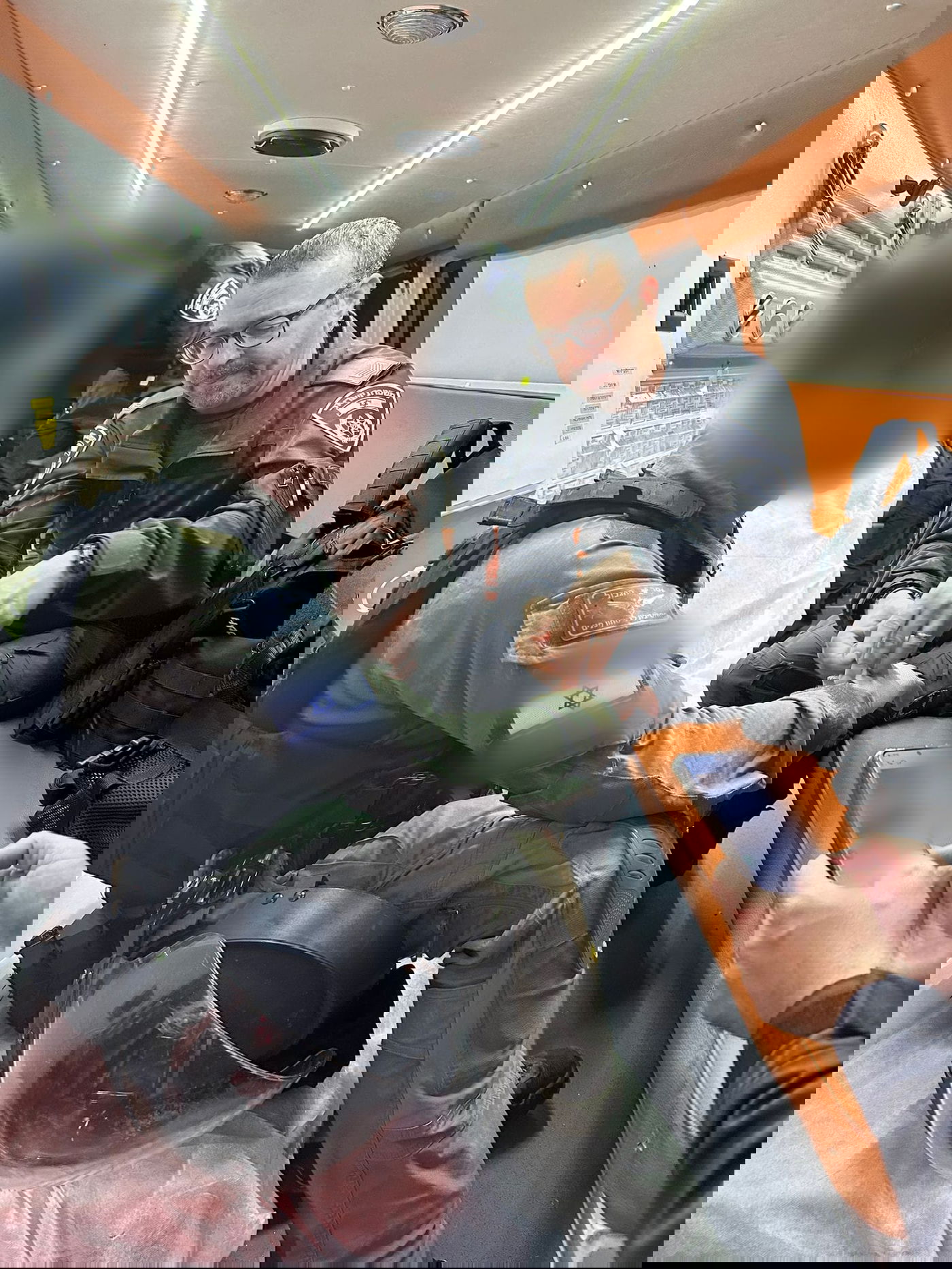 שוטרים שמים פלסטר בתוך ניידת אמבולנס על ידו של שוטר שנפצע מאלימות המתפללים