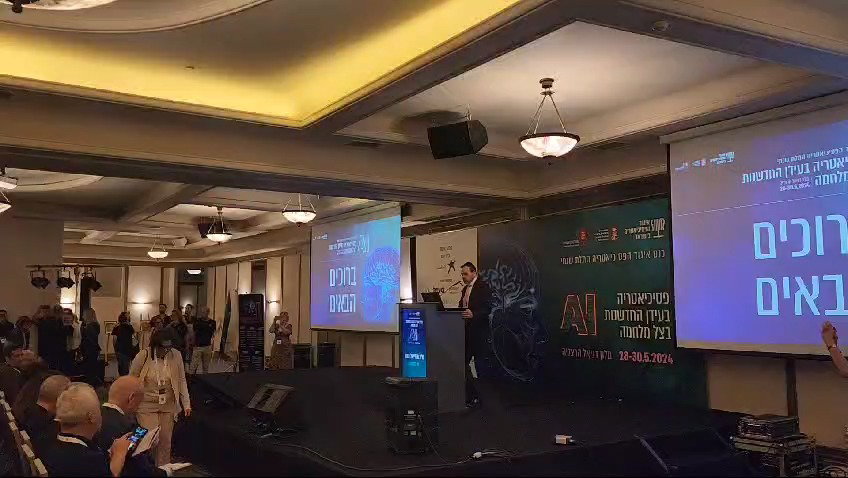 השר בוסו נואם על רקע צעקת המפגינים