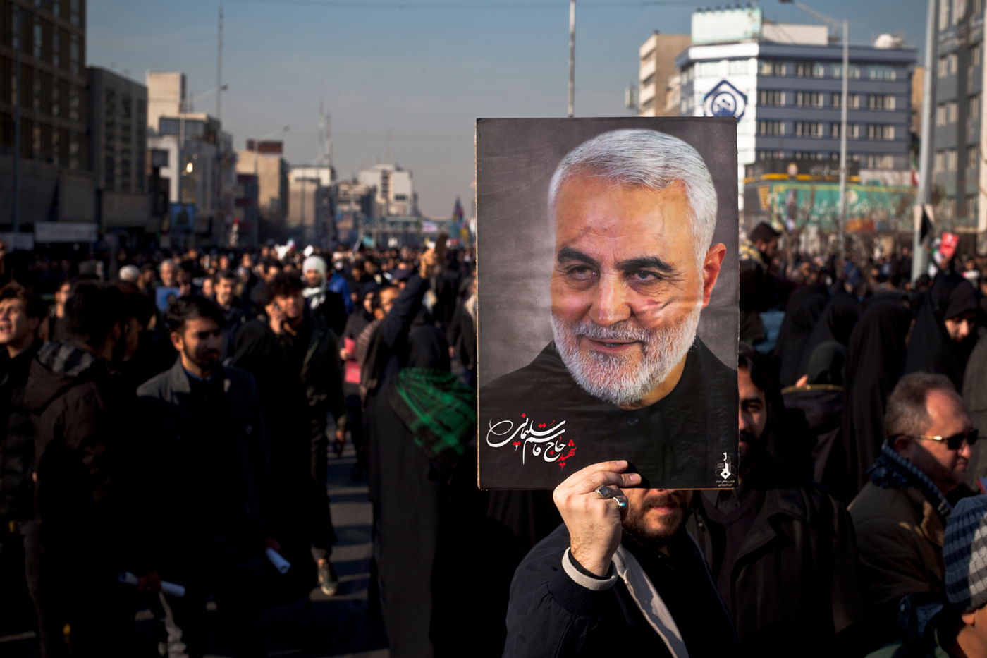 מפגינים מניפים את תמונתו של ה"שהיד" קאסם סולימאני