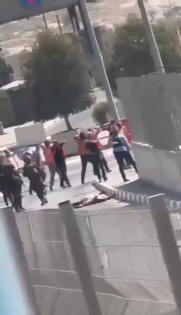 פועלים ירדנים נלקחים לחקירה. ברקע: גופת המחבל