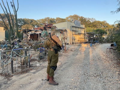 מנדי אושר על רקע ניר עוז והשלט המיתולוגי שנשמר על הדרך לגוש קטיף