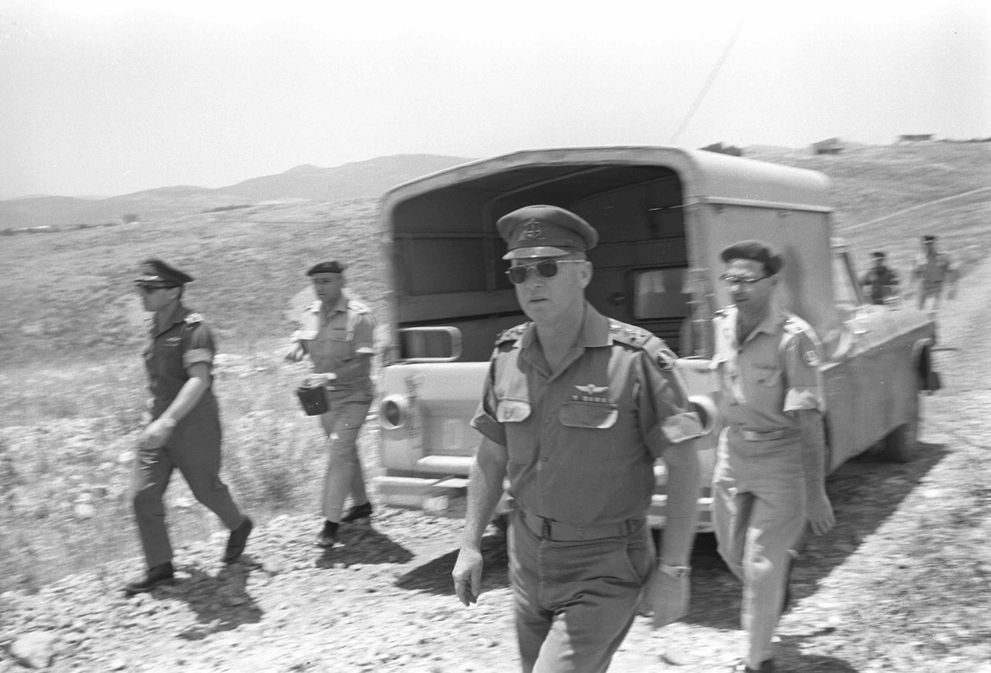 הרמטכ"ל רא"ל יצחק רבין בשיחה עם מפקד פיקוד הדרום אלוף ישעיהו (שייקה) גביש, חובש כומתה בגבו למצלמה. משמאלו אל"מ אברהם (אברשה) טמיר, רמ"ח תכנון וארגון באג"ם, קיצוני מימין אל"מ יעקב חפץ יועץ כספי לרמטכל, ובינו ובין רבין ניצב אל"ם מרדכי ציפורי, מח"ט 14