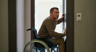 אדם עם מוגבלות מנסה להיכנס לחדר, אך לא יכול בשל המעבר הצר