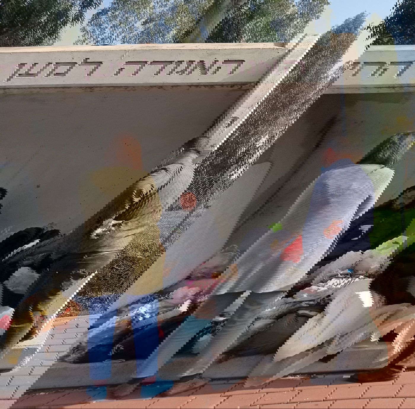 אנשים עוזרים לחסר בית שמתגורר בתחנת אוטובוס