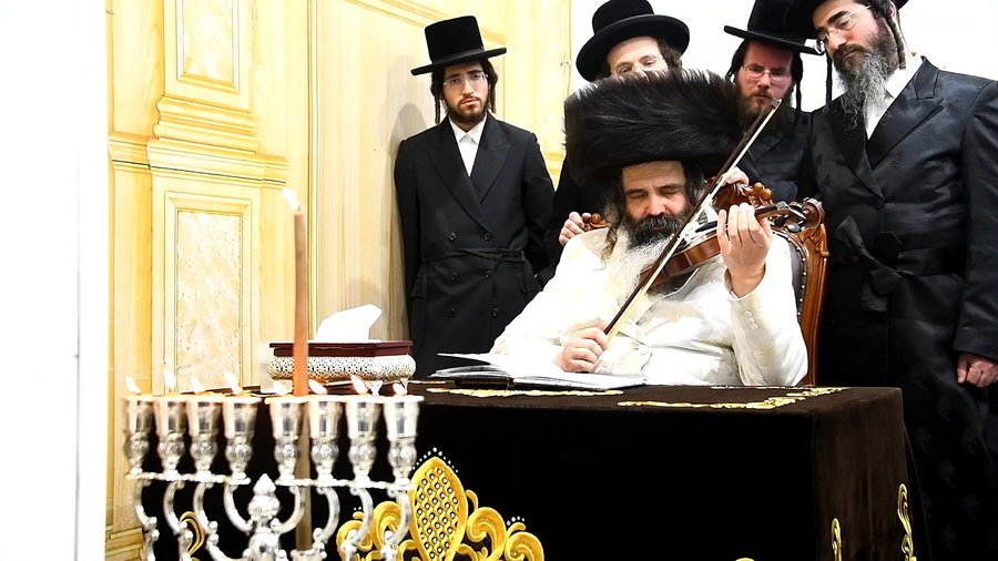 האדמו"ר מזוטשקא מנגן בכינור בסיום מעמד ההדלקה