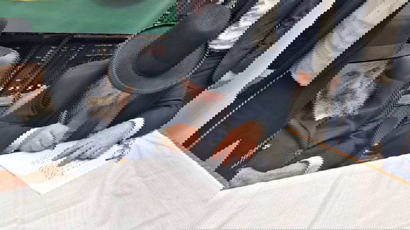 הגר"א סאלים חותם על המכתב בפני ראש הישיבה הגר"ד לנדו