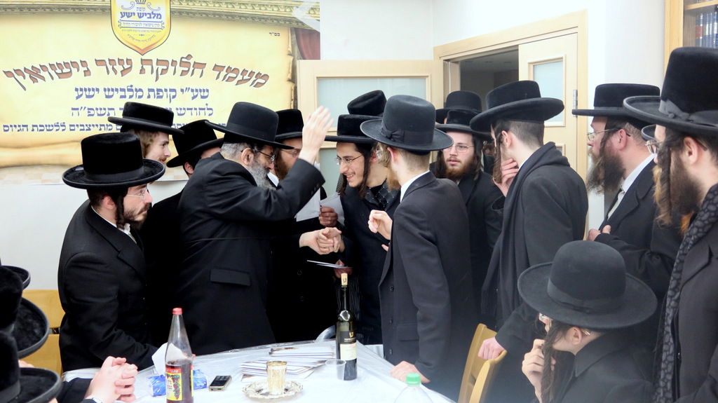 הגה"צ רבי צבי מאיר זילברברג בחלוקת שוברי השטריימלעך לחתנים