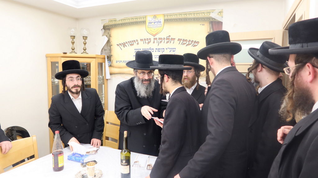 הגה"צ רבי צבי מאיר זילברברג בחלוקת שוברי השטריימלעך לחתנים