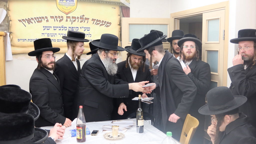 הגה"צ רבי צבי מאיר זילברברג בחלוקת שוברי השטריימלעך לחתנים