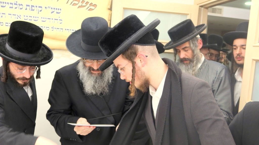הגה"צ רבי צבי מאיר זילברברג בחלוקת שוברי השטריימלעך לחתנים