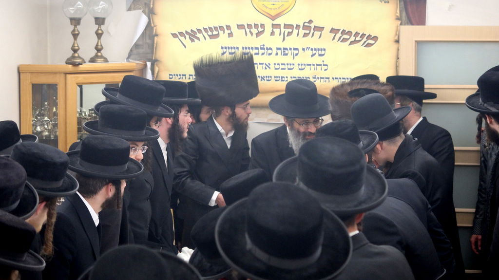 הגה"צ רבי צבי מאיר זילברברג בחלוקת שוברי השטריימלעך לחתנים