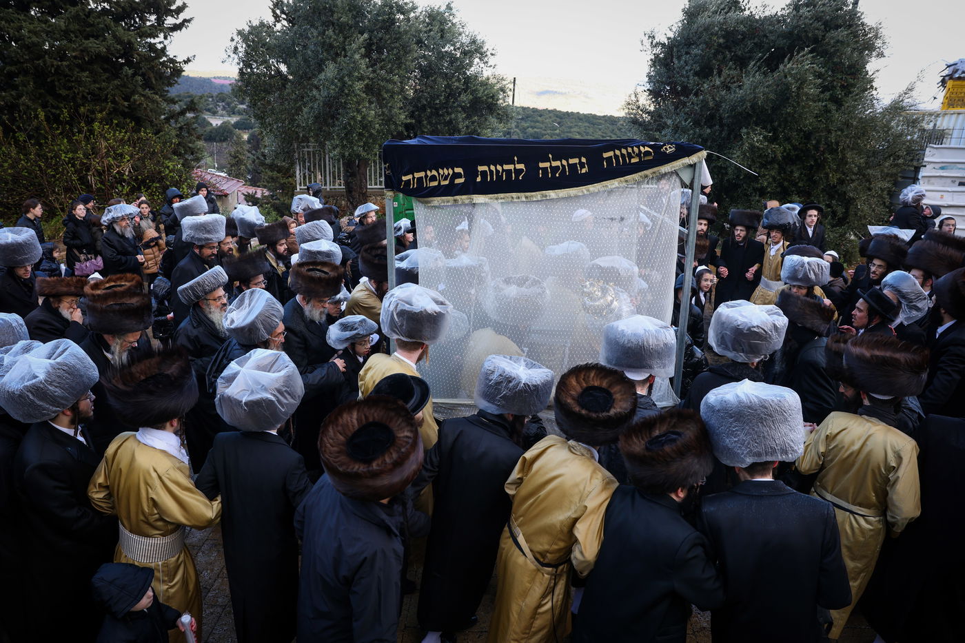 חסידי תולדות אהרון בהכנסת ספר תורה תחת גשם שוטף בציון הרשב"י במירון