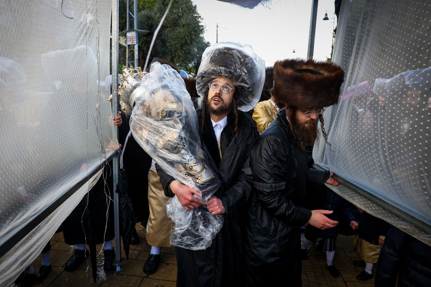חסידי תולדות אהרון בהכנסת ספר תורה תחת גשם שוטף בציון הרשב"י במירון