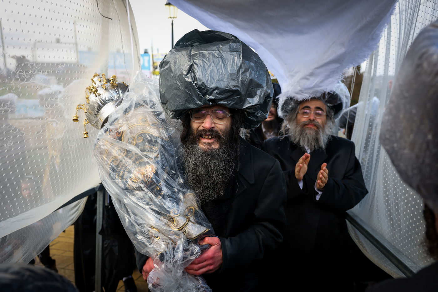 חסידי תולדות אהרון בהכנסת ספר תורה תחת גשם שוטף בציון הרשב"י במירון