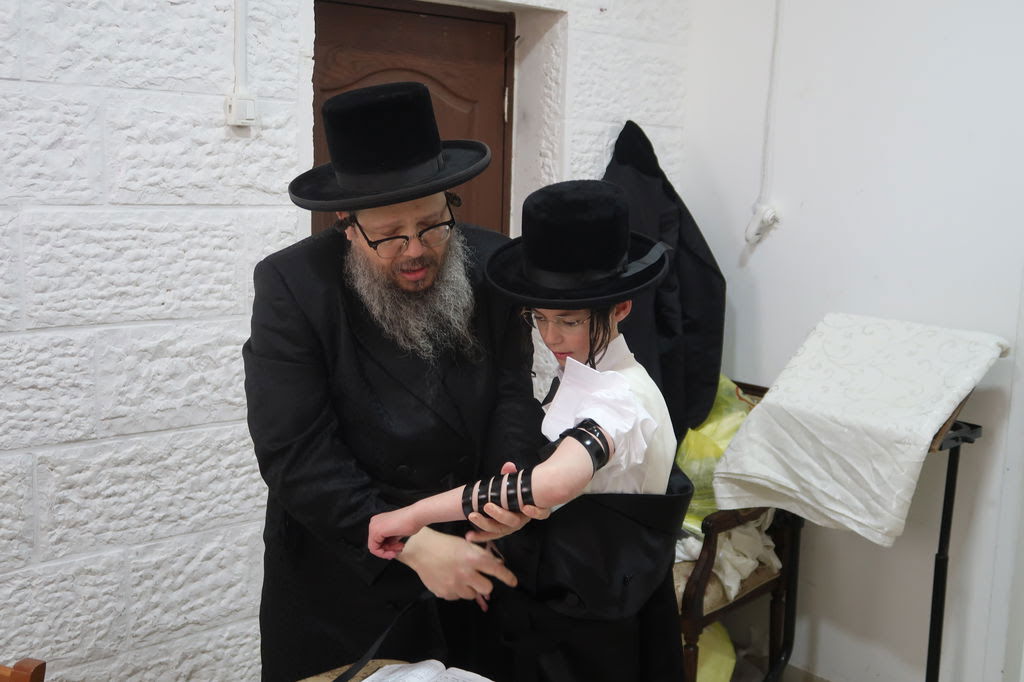 האדמו"ר מבוסטון ביתר בהנחת תפילין לנכדו בכורו