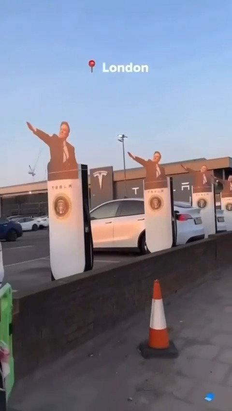 מיצג של מאסק מצדיע במועל יד על עמדות טעינה של טסלה בלונדון
