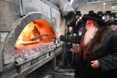 האדמו"ר מצאנז בזריקת עצים לתוך תנור המצות בליל י"ג ניסן