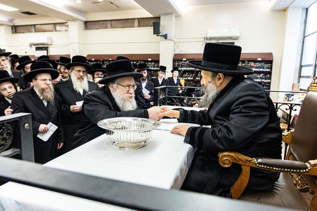 חסידי באבוב 45 נותנים קוויטלעך לרבם לפני המסע לצאנז