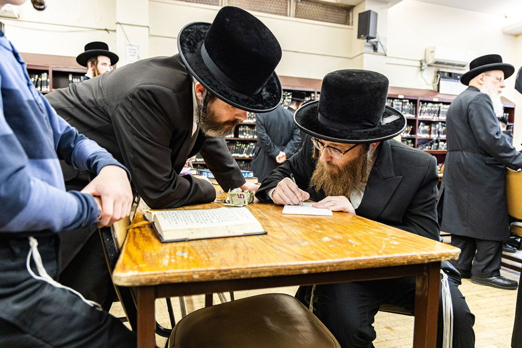 חסידי באבוב 45 נותנים קוויטלעך לרבם לפני המסע לצאנז