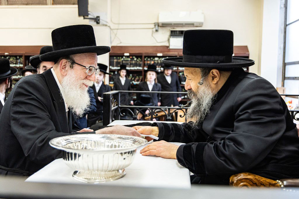 חסידי באבוב 45 נותנים קוויטלעך לרבם לפני המסע לצאנז