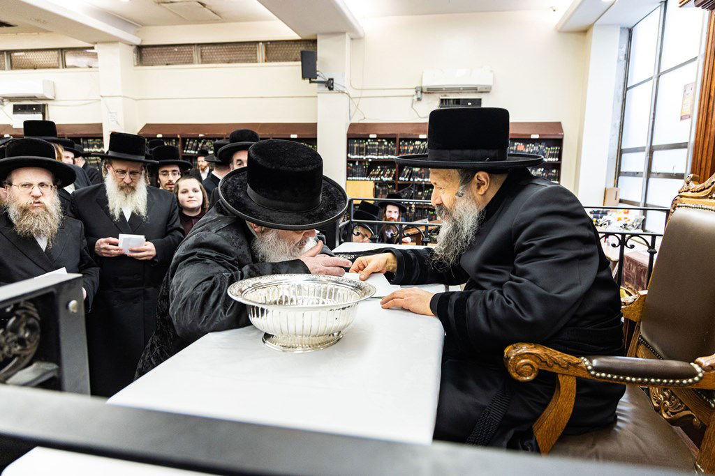חסידי באבוב 45 נותנים קוויטלעך לרבם לפני המסע לצאנז