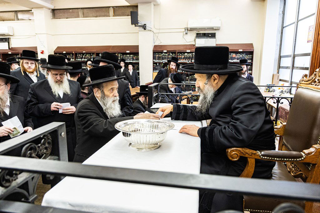 חסידי באבוב 45 נותנים קוויטלעך לרבם לפני המסע לצאנז