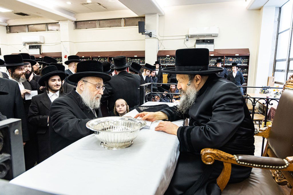 חסידי באבוב 45 נותנים קוויטלעך לרבם לפני המסע לצאנז
