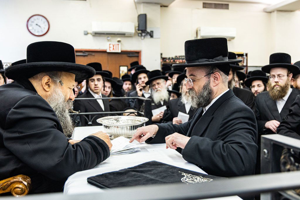 חסידי באבוב 45 נותנים קוויטלעך לרבם לפני המסע לצאנז