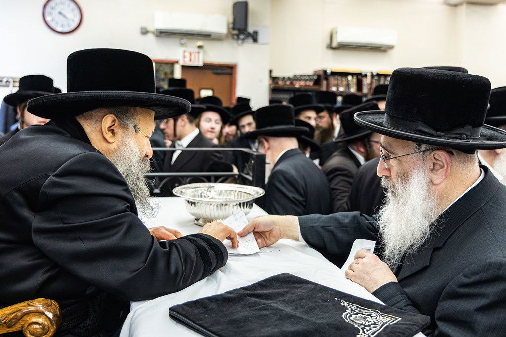חסידי באבוב 45 נותנים קוויטלעך לרבם לפני המסע לצאנז