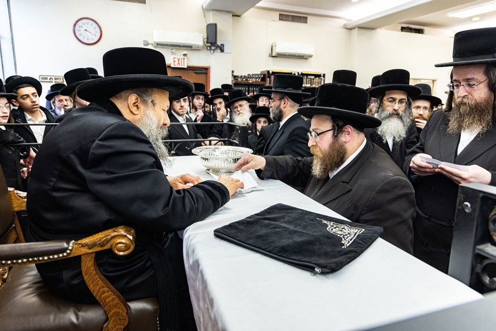 חסידי באבוב 45 נותנים קוויטלעך לרבם לפני המסע לצאנז