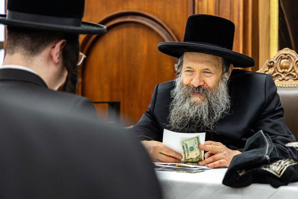 חסידי באבוב 45 נותנים קוויטלעך לרבם לפני המסע לצאנז