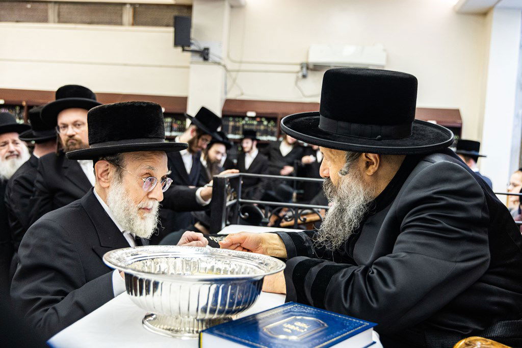 חסידי באבוב 45 נותנים קוויטלעך לרבם לפני המסע לצאנז