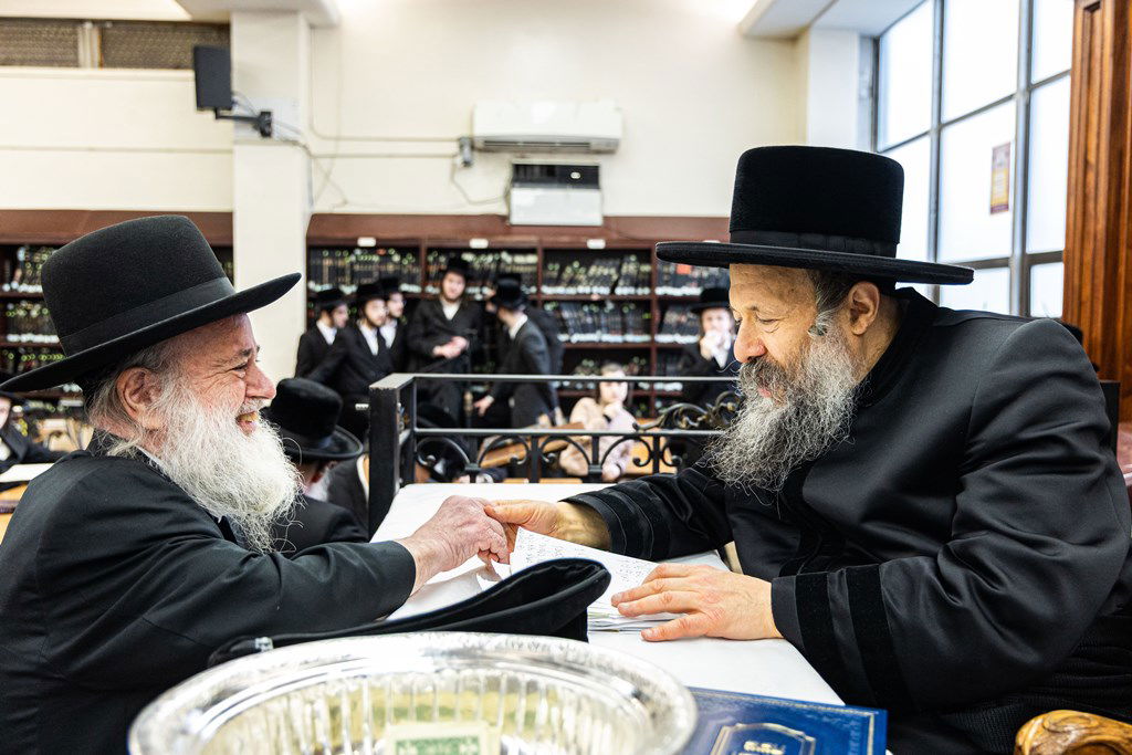 חסידי באבוב 45 נותנים קוויטלעך לרבם לפני המסע לצאנז