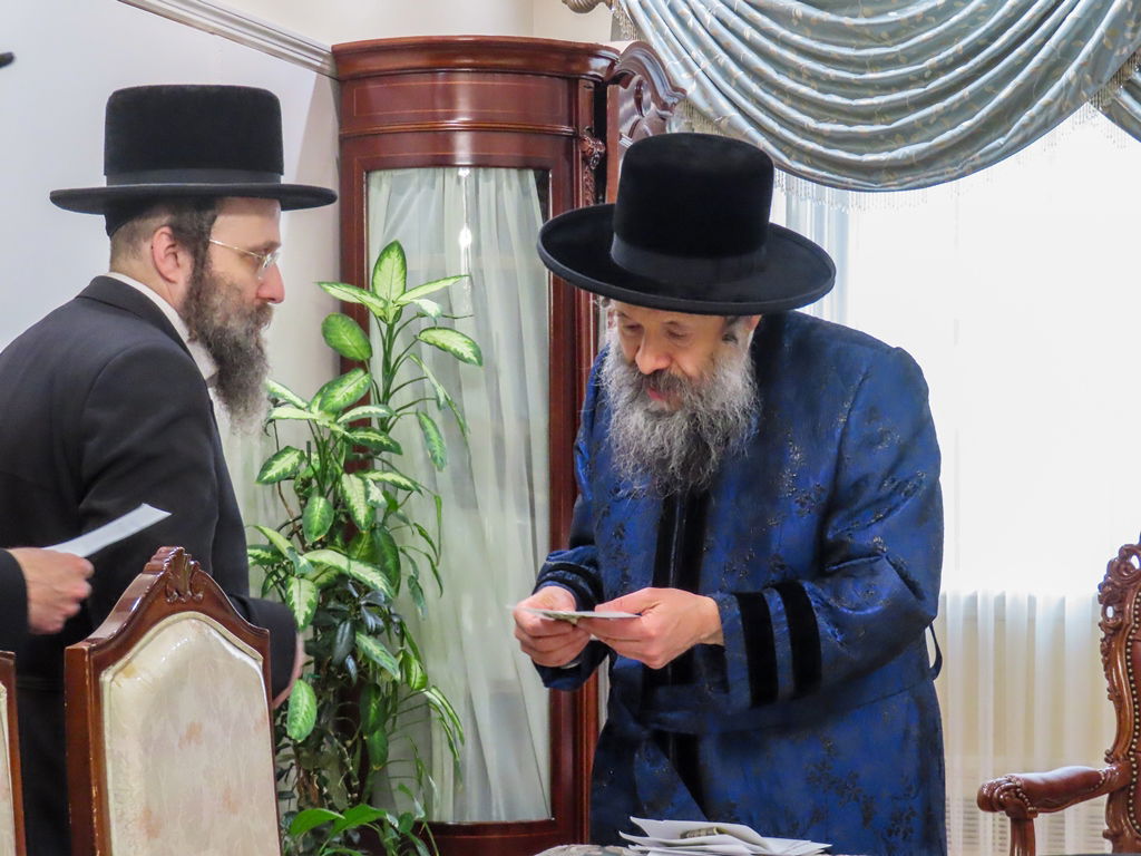 חסידי באבוב 45 נותנים קוויטלעך לרבם לפני המסע לצאנז