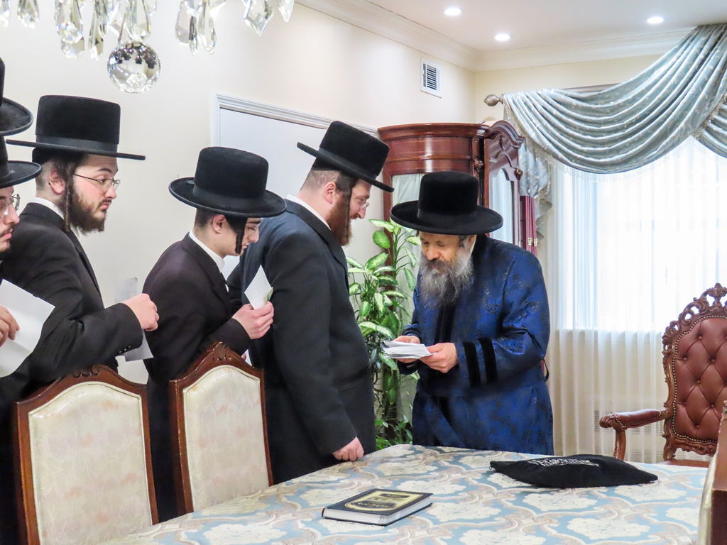 חסידי באבוב 45 נותנים קוויטלעך לרבם לפני המסע לצאנז