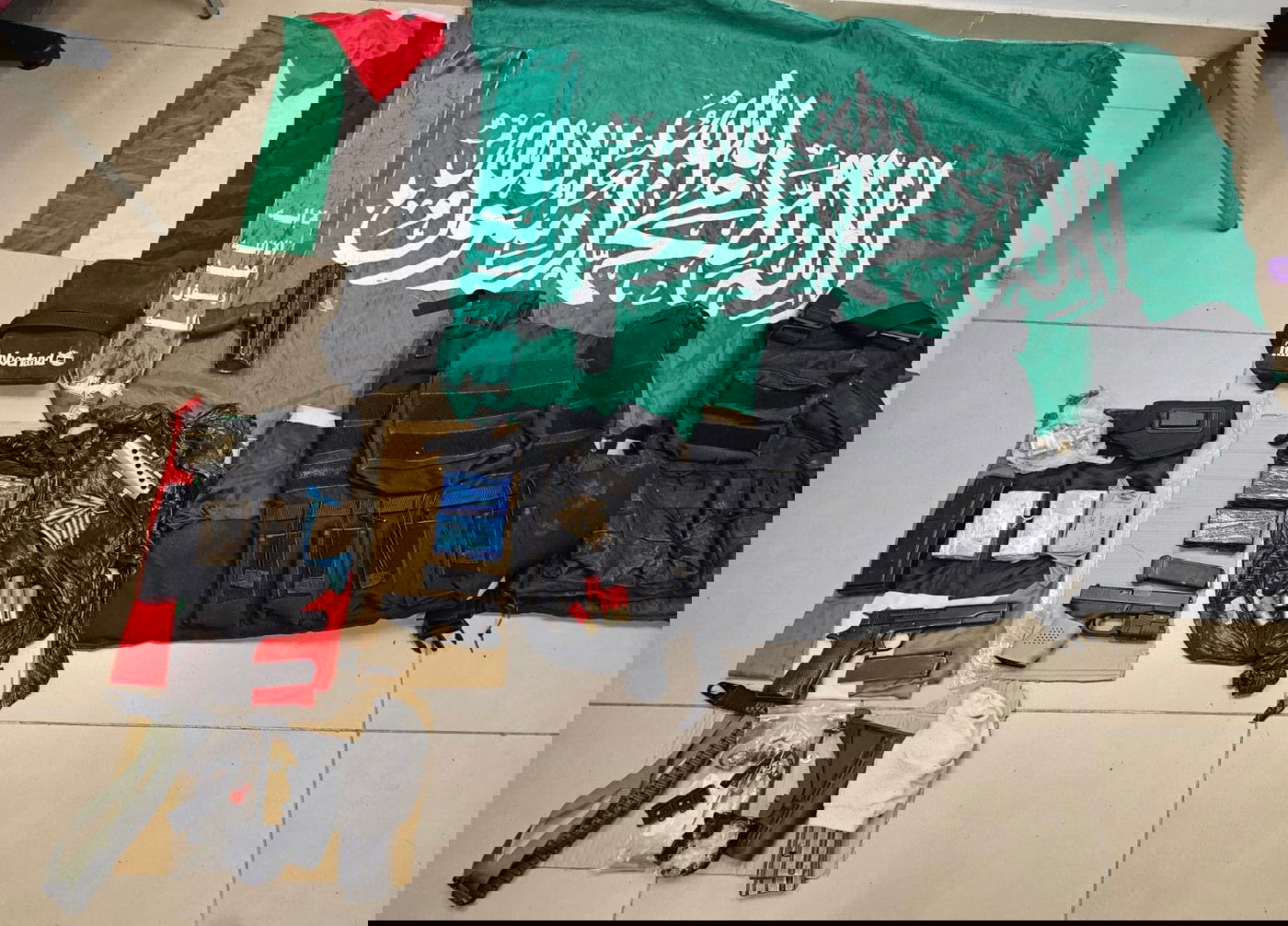 תמונה מהאמל״ח, דגל וצעיף של ארגון הטרור אשר נתפסו ע״י השוטרים בעת החיפוש.