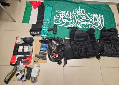 תמונה מהאמל״ח, דגל וצעיף של ארגון הטרור אשר נתפסו ע״י השוטרים בעת החיפוש.