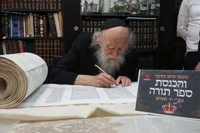 רבי שמעון גלאי כותב אות בספר התורה של יד לאחים