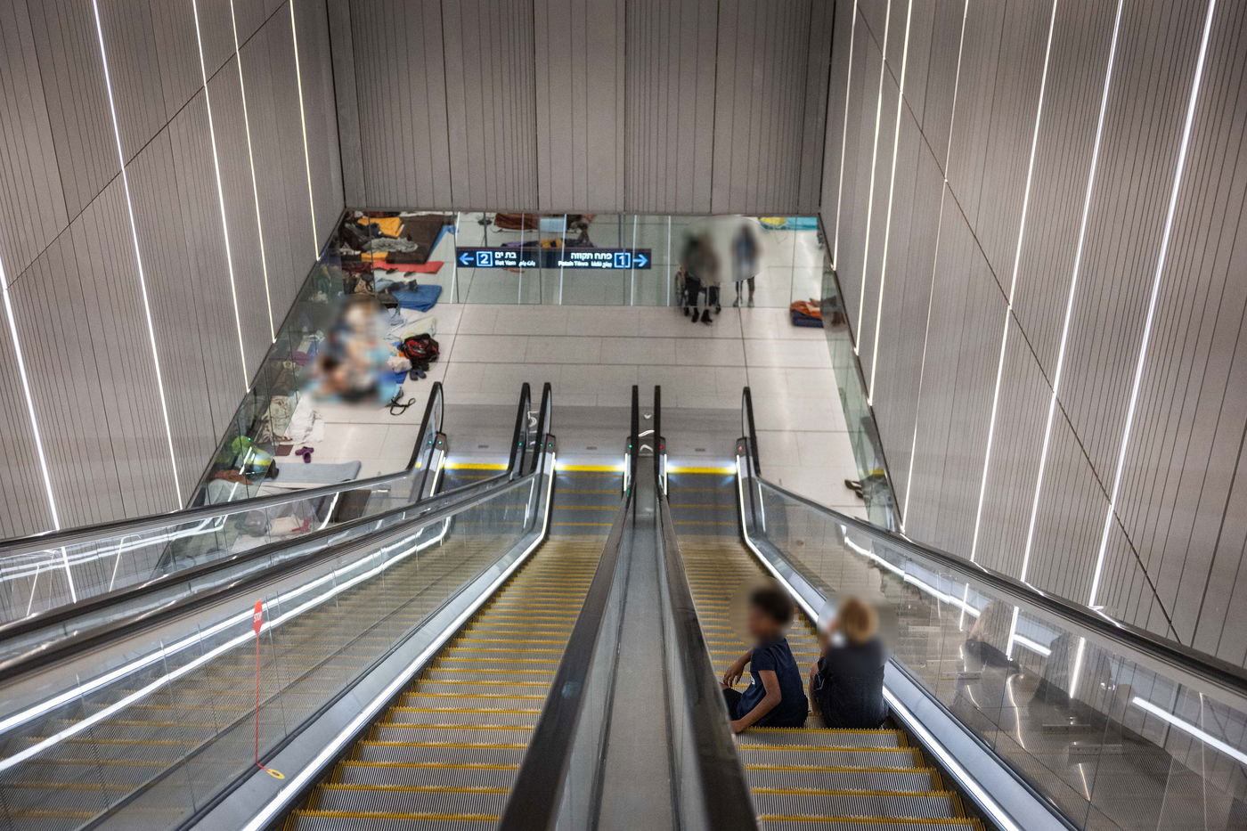 אזרחים תופסים מחסה לילי בתחנת הרכבת הקלה בתל אביב