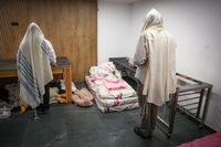 מתפללים במקלט בצפת במהלך אזעקה