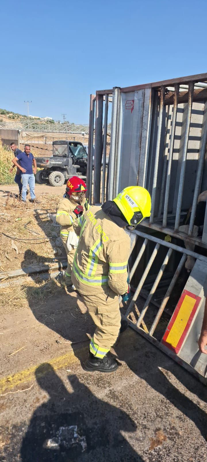 לוחמי האש מחלצים את הפקות המשאית ההפוכה