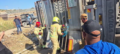 לוחמי האש מחלצים את הפקות המשאית ההפוכה